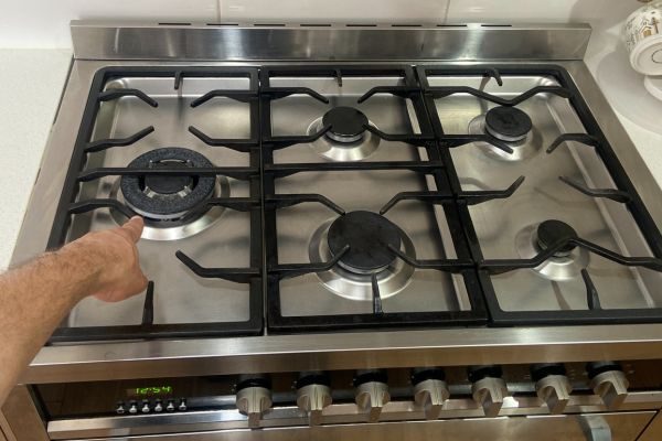 Technician pointing at a faulty gas stove burner during a Quality Appliance Repairs service call in Adelaide.