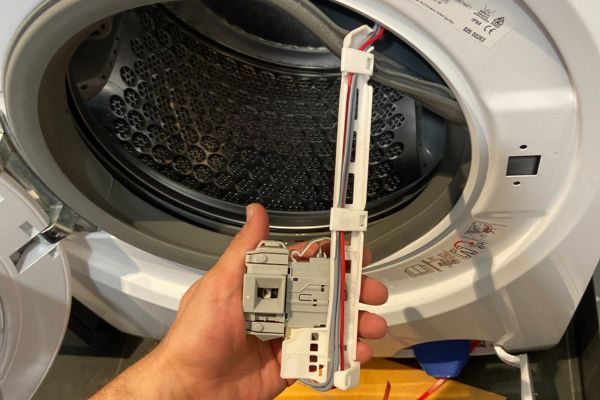 Technician repairing a front load dryer component in Brisbane home