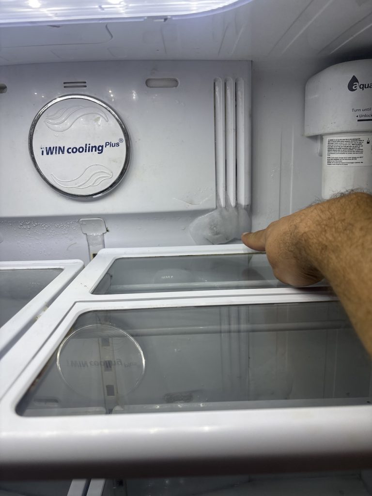 freezer repairs technician checking the ice build-up 